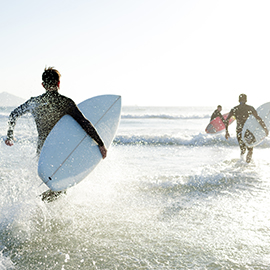 surfers running into the ocean